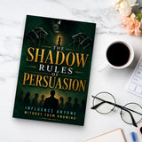 The Shadow Rules of Persuasion - paperback beside a cup