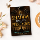 The Shadow Rules of Persuasion - paperback beside writing materials